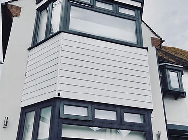 Freshly prepped and painted house exterior with grey cladding and windows, completed by BilnerBuilds