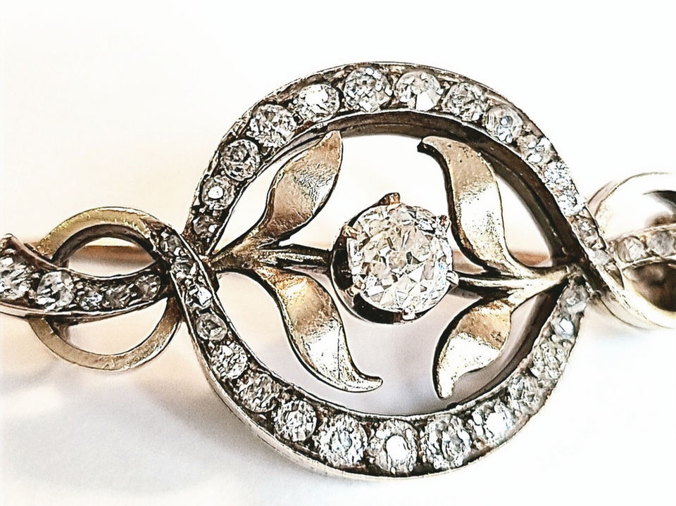 round arches in the center with two leaves in the middle and a large diamond in the middle of them and the leaves curl outwards