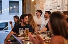 Grupo de amigos tomando cerveza alrededor de una mesa en Mendrugo.webp
