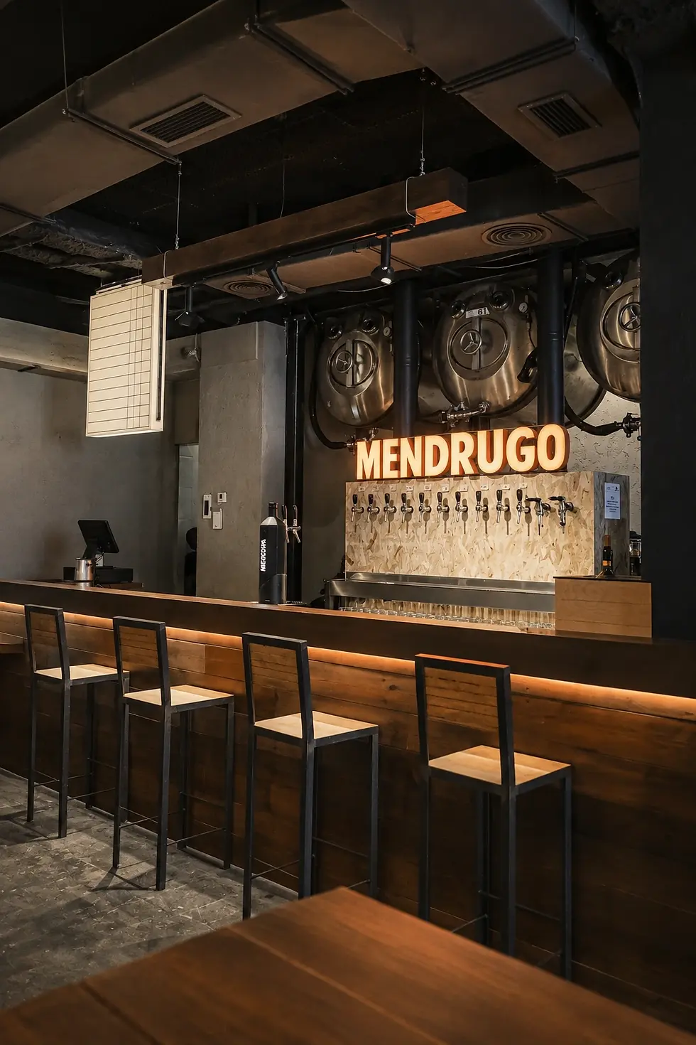Barra de Mendrugo con taburetes, grifos de cerveza y depósitos metálicos.webp