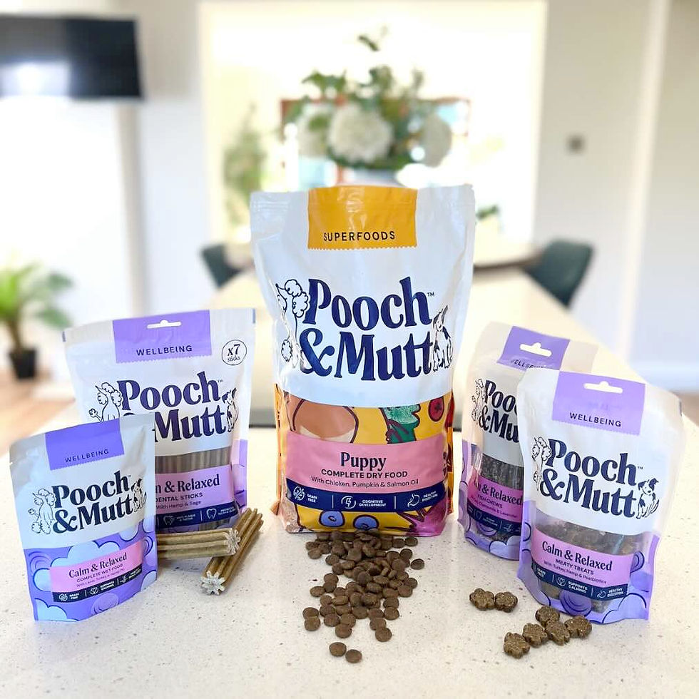 Pooch & Mutt dog food and treats bags on a kitchen table, with kibble and dental sticks, in a bright home setting.
