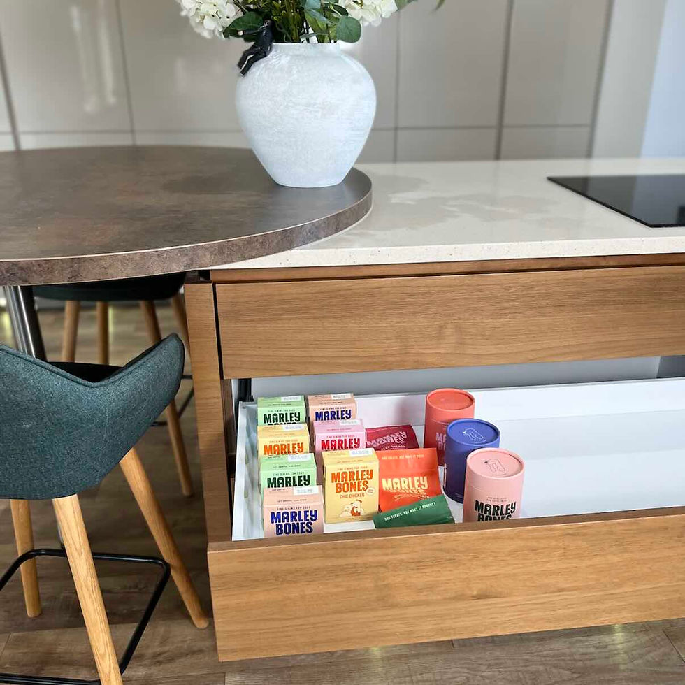 Wooden kitchen drawer open with various Marleybones pet food packages. 