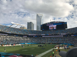 a photo from inside Bank of America stadium showing the Charlotte skyline in the background, before a Carolina Panthers game