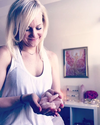 Noelle is holding Rose Quartz crystals in her hands.