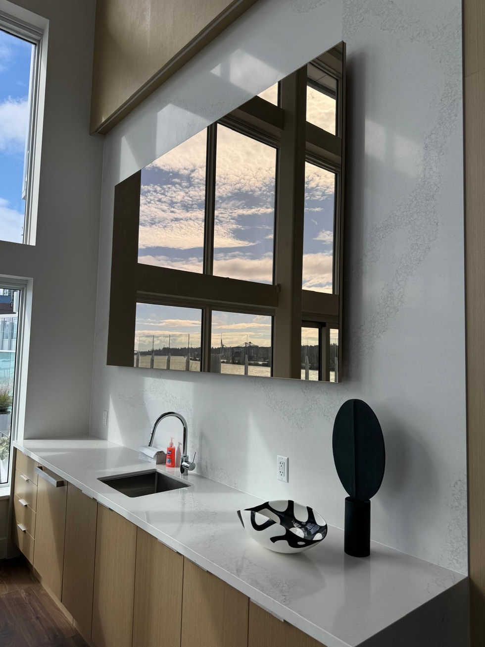 Inset frameless mirror installed behind custom shelving, adding depth and a modern reflective accent to the space