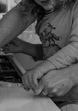 A kid helping a mom cut butter