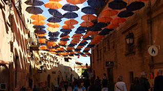 Paraplyer som hänger dekorativt ovanför en gata i Barcelona