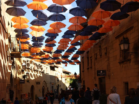 Paraplyer som hänger dekorativt ovanför en gata i Barcelona