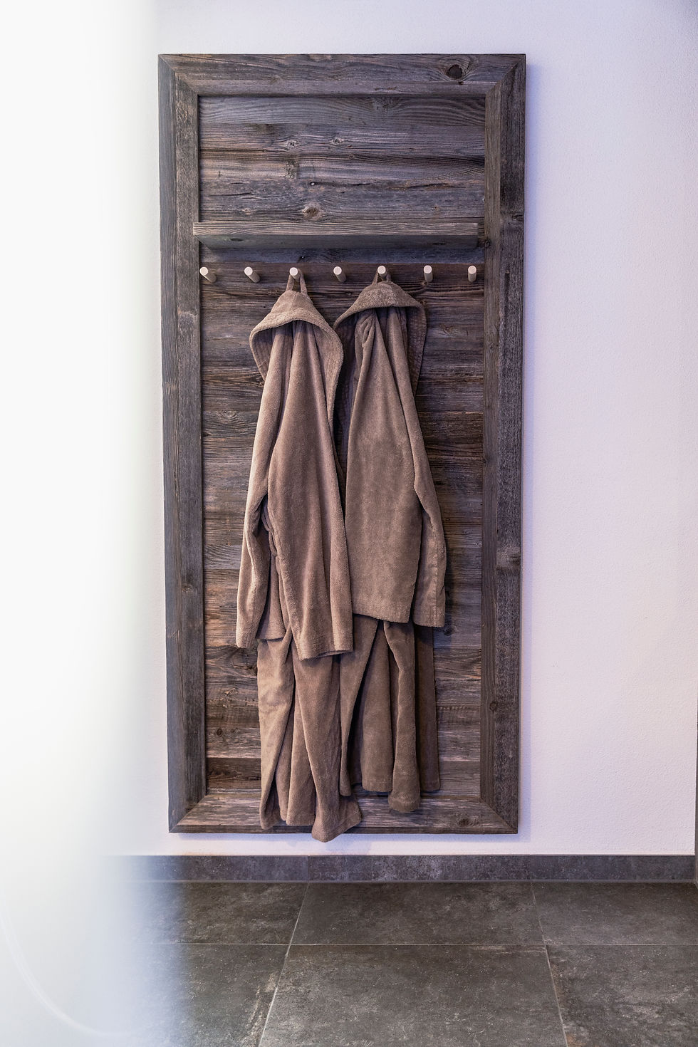 Wellness-Bademäntel an rustikaler Holzwand