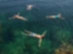 People floating on their backs in clear blue-green water - Getty Images for Unsplash