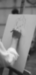 Picture of an artist drawing on a canvas on an easel