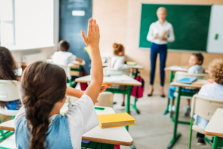 rear-view-of-schoolgirl-raising-hand-to-answer-tea.jpg