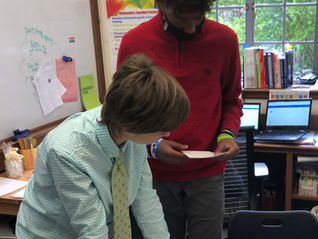 Two students discussing a slope sort in pre-algebra class.
