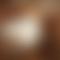 An open notebook with "Thanksgiving Gratitude" written on the pages sitting on a wooden table by a cup of tea