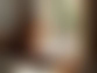 A calm, cozy scene with a woman journaling near a window, soft natural light, a warm drink nearby, and a relaxed, peaceful atmosphere—no hustle vibes.