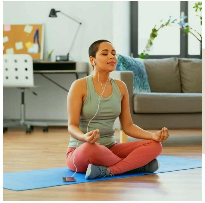 A young woman embraces tranquility as she follows a guided meditation on her phone, sitting peacefully in her living room.