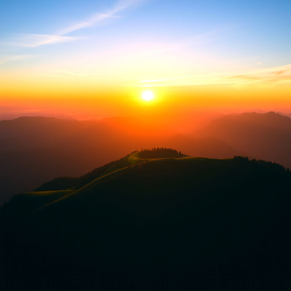 The sun sets over a silhouetted mountain range
