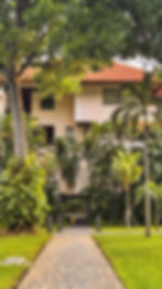 Fachada de villa de lujo rodeada de árboles, con arquitectura tropical pensada para bienestar residencial.