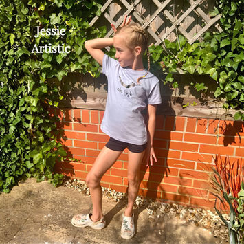 Jessie Artistic posing in a grey t-shirt and shorts.