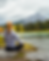 girl meditating next to a lake