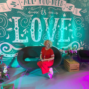 Andrea with her stall, with an 'All you need is love' backdrop