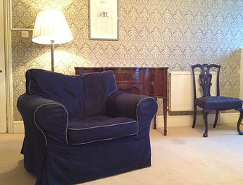 A single-seat couch in a calm, thoughtfully designed therapy room at Psyche Clinic