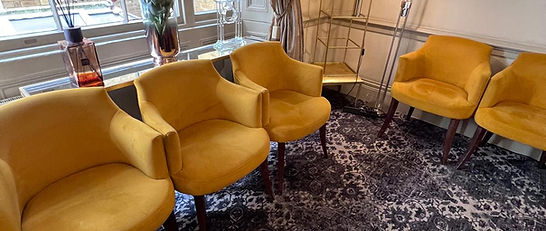 Bright yellow armchairs in a modern therapy room at Psyche Clinic, creating a warm and inviting space.
