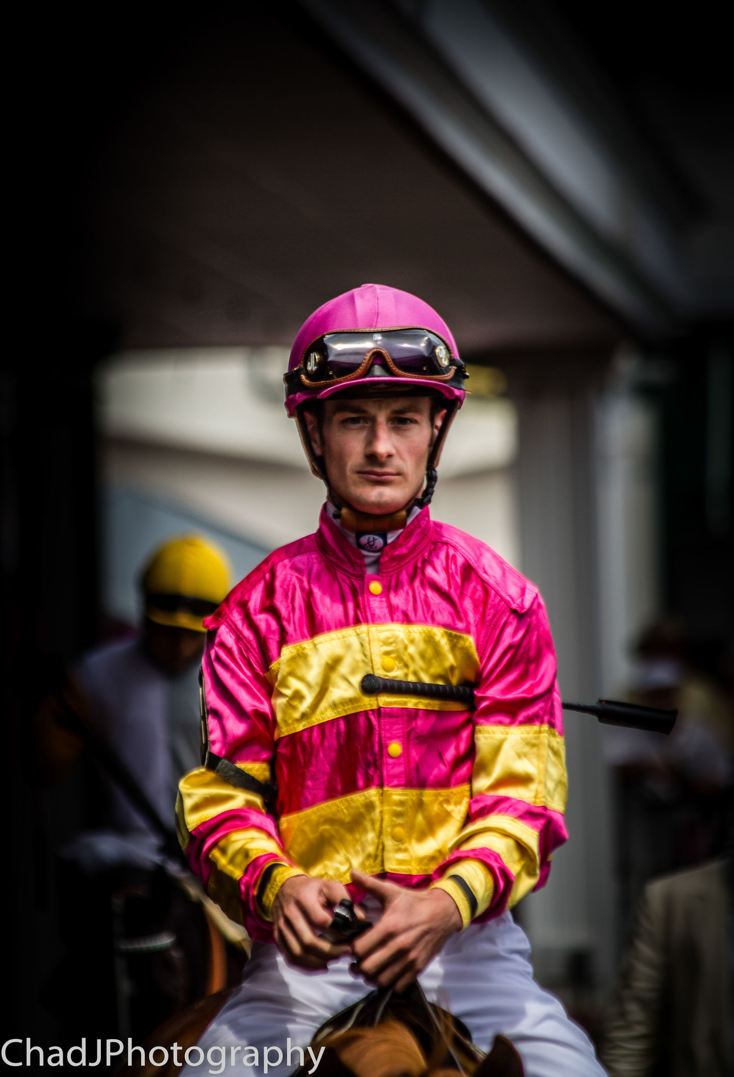 a jockey wearing a pink helmet and goggles