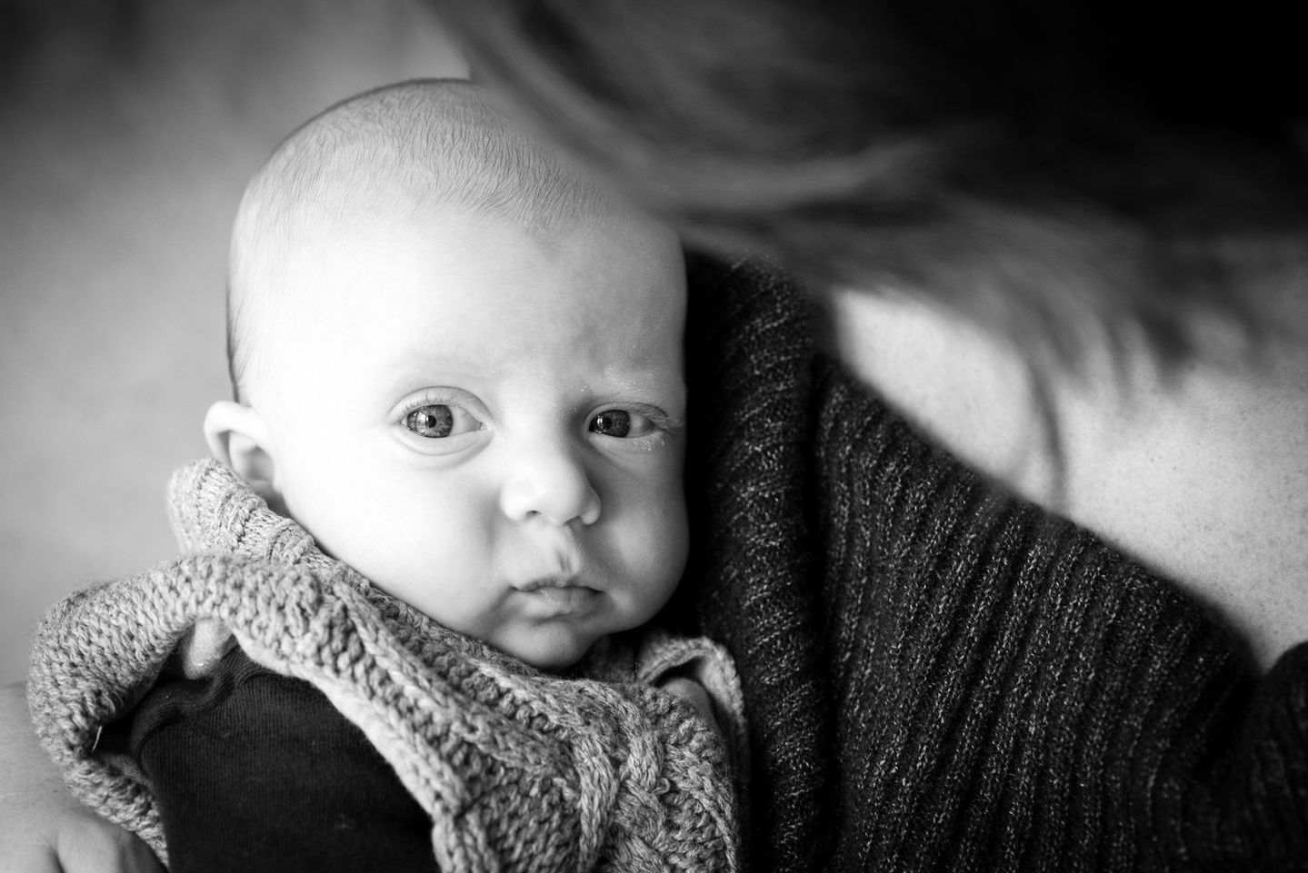 a black and white photo of a woman holding a baby