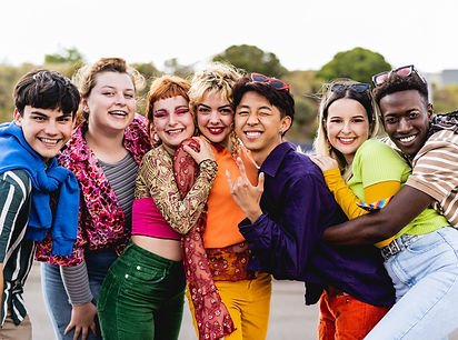 A group of seven LGBTQ+ youth all posing together