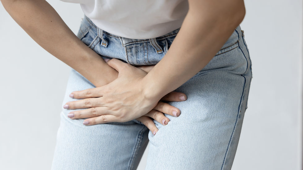 Person with bladder symptoms wearing blue jeans holding hands over bladder region.