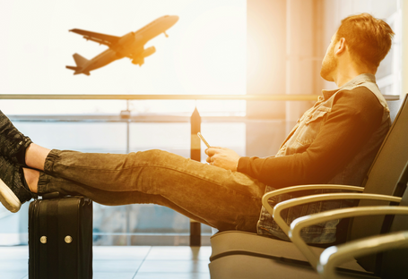Passageiro prejudicado no transporte aéreo observando avião partir