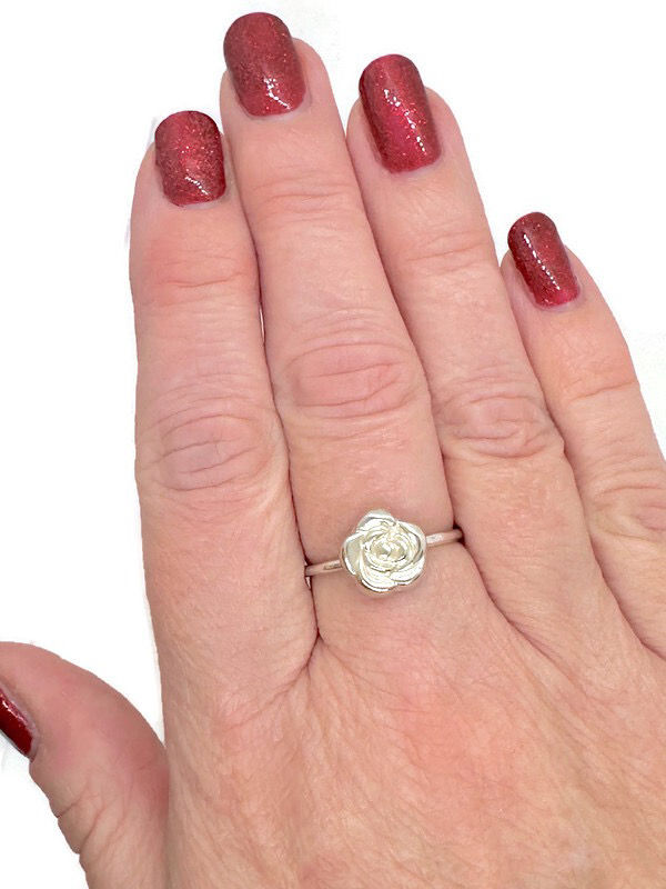 Thumbnail: silver rose ring being worn on middle finger