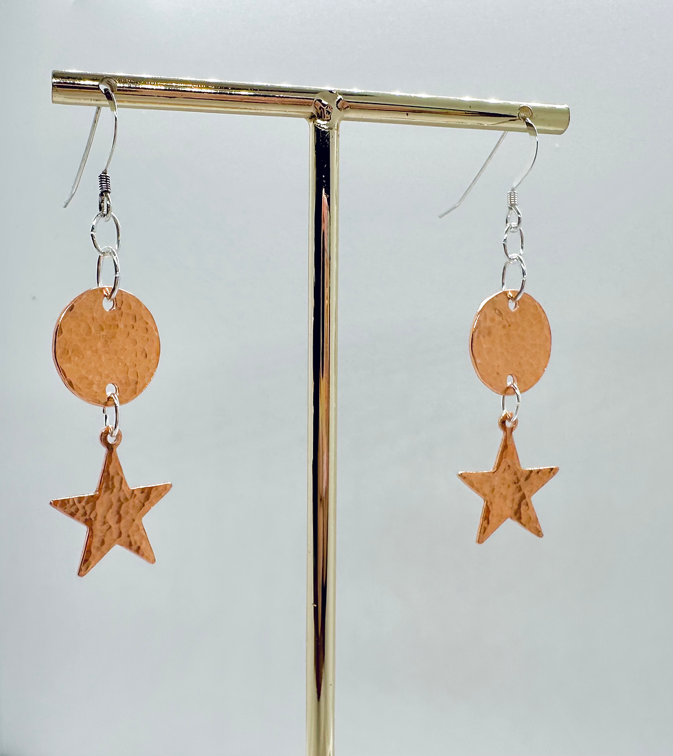 Thumbnail: copper star dangle earrings hanging from gold display stand