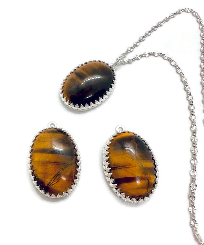 Thumbnail: three oval tigers eye gemstones on white background