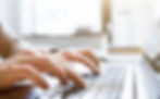 a closeup of hands typing on a laptop
