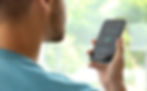 A man in a blue shirt using voice search on his phone