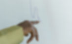 A hand points to a blue line graph on a white screen, indicating fluctuating data. The setting appears professional and analytical.