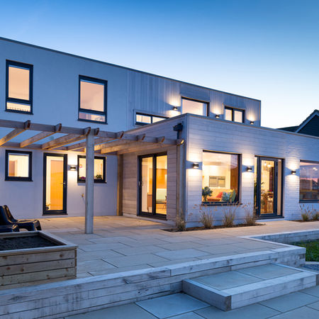 Exterior view of Riverside Shoreham house showing new two‑storey extension with large picture windows overlooking garden