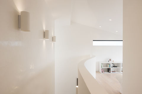Sleek white upstairs hallway with contemporary staircase and banister at Eileen Avenue, Brighton, by LRAR Architects, Brighton