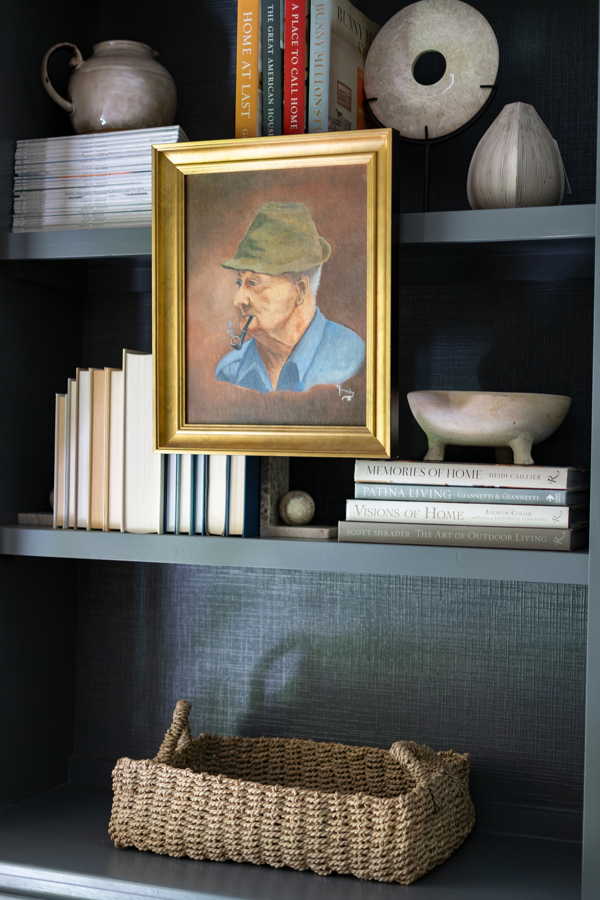 gold framed oil painting of older man mounted on a bookcase