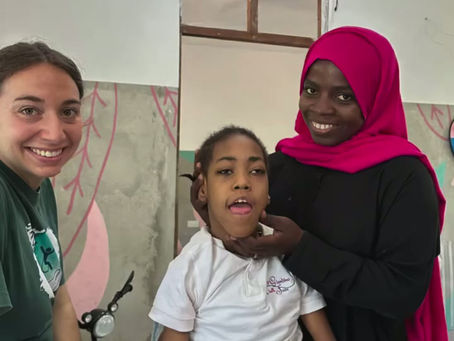 zwei Physiotherapeutinnen beim Sitztraining mit einem Kind