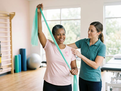 Fisioterapeuta acompanha mulher em exercício para recuperar o movimento do ombro após o câncer de mama