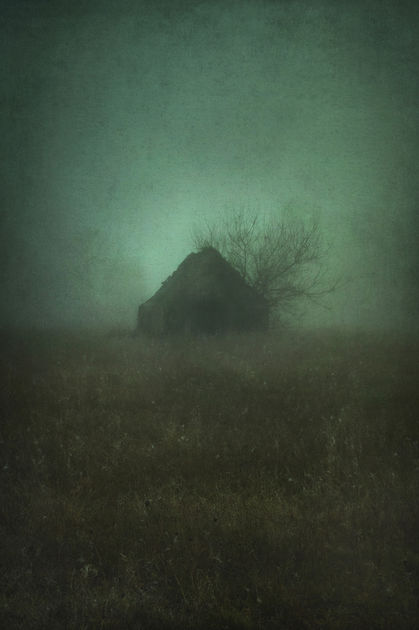 Dark and moody photograph of an abandoned barn in a painterly style