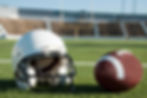 Photo of a helmet and football in a college football stadium