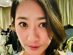 於宴會廳的女人自拍照,嘴角帶笑,眼睛亮晶晶