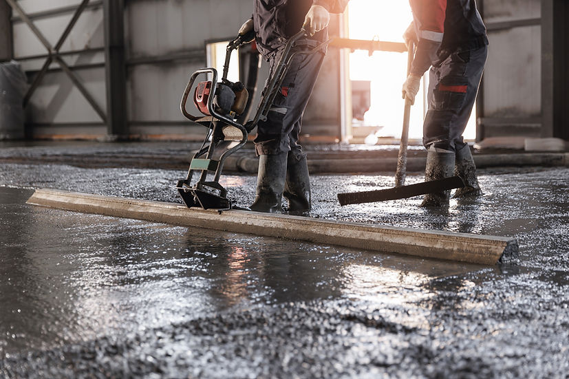 Team Workers uses vibrating machine to level cement mortar for floors. Concrete screed for