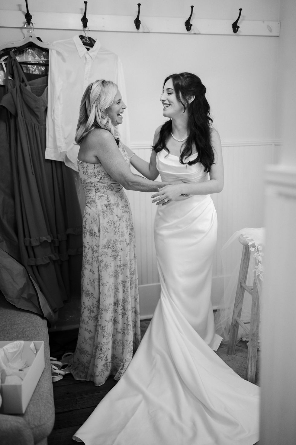 Bride smiling with her mother after stepping into her gown in The Cottage at 128 South