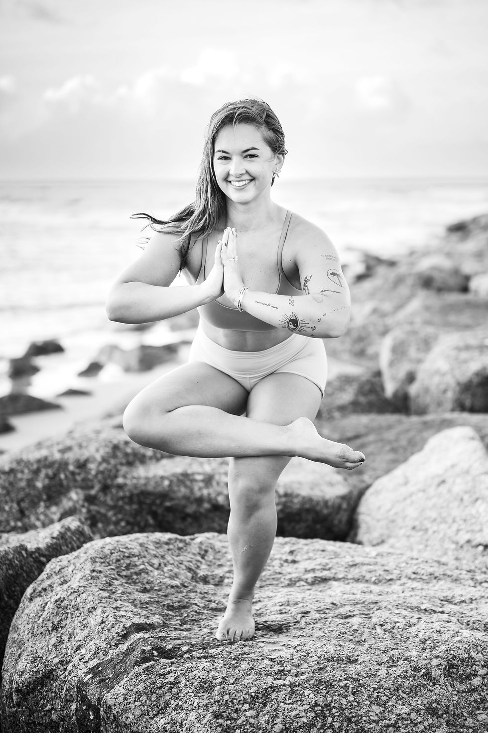 Yoga and Pilates instructor performing an intentional movement sequence on the east end of Ocean Isle Beach. Lifestyle branding photography showcasing strength and coastal wellness in North Carolina.