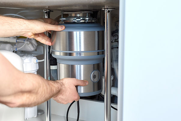 Plumber installing sink garbage disposal